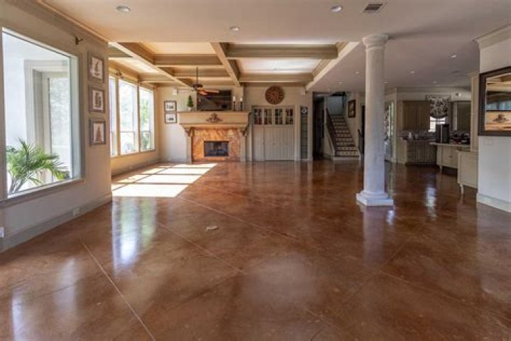Can you tile over a stained concrete floor
